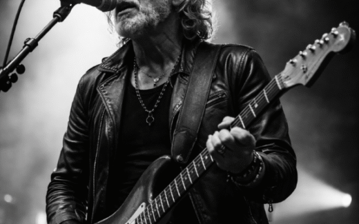 Older musician with electric guitar in black and white